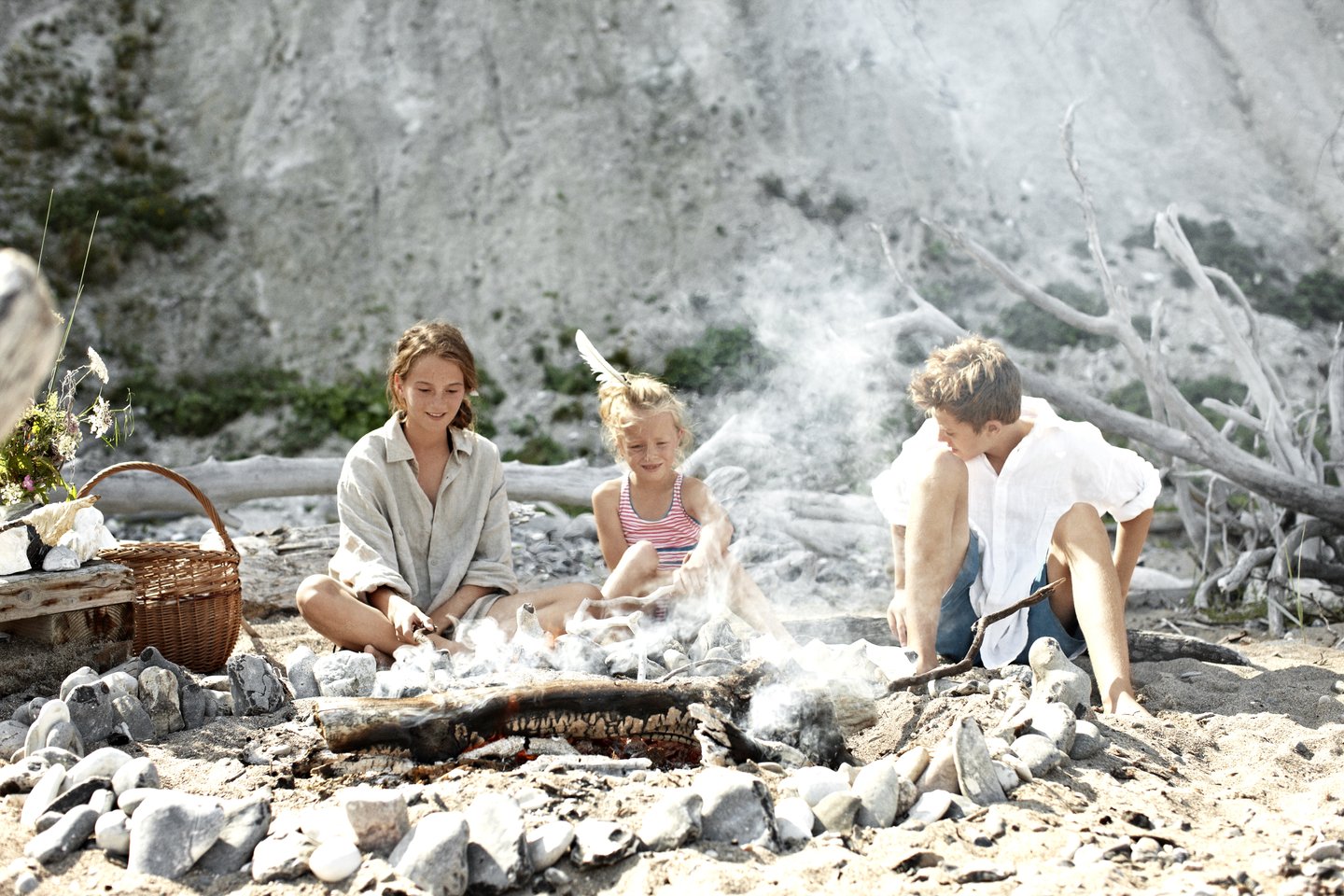 A family baking twist breads on a beach, South Zealand, Møn and Lolland-Falster