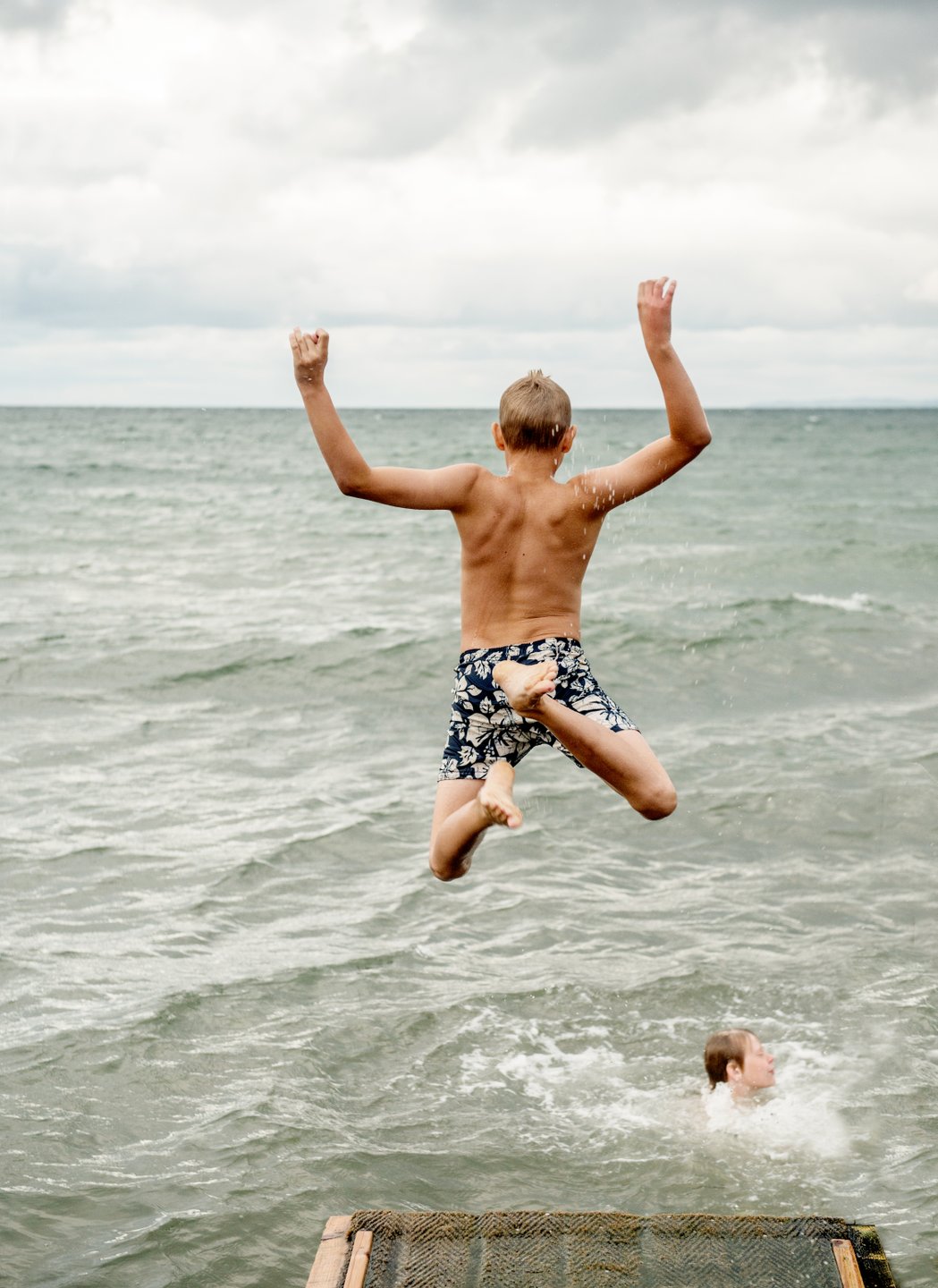 Boy jumping into the water at Gilleleje Beach in North Zealand