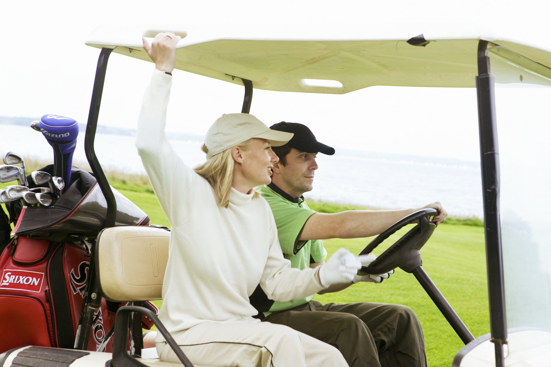 Two people in a golf car
