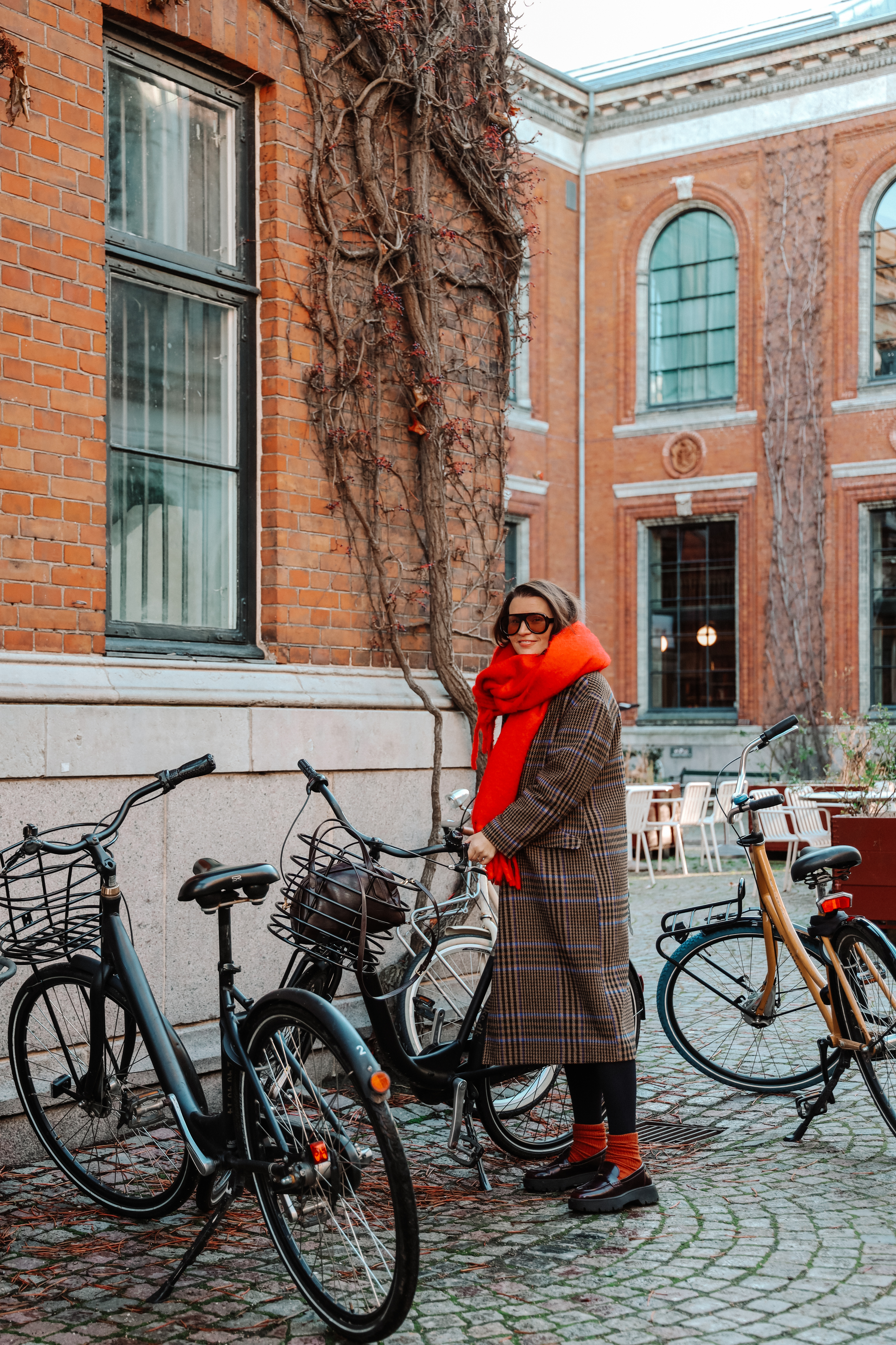 Kvinne ved bygning og sykkel i København