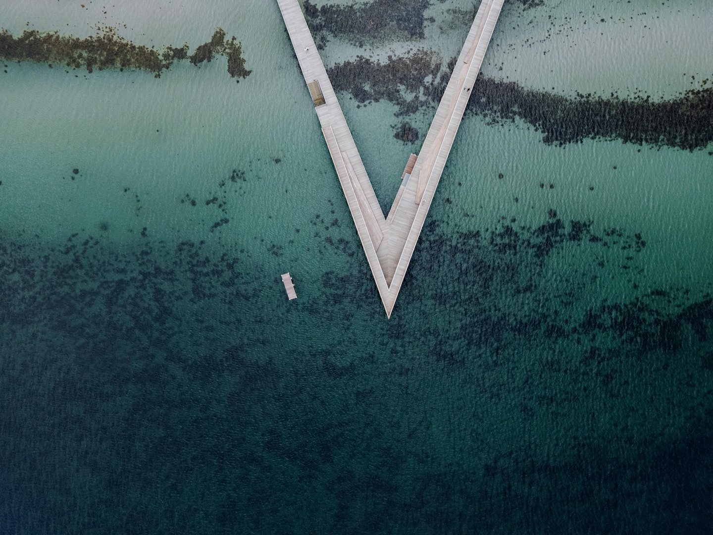 Aerial view of a V-shaped pier extending into the sea.