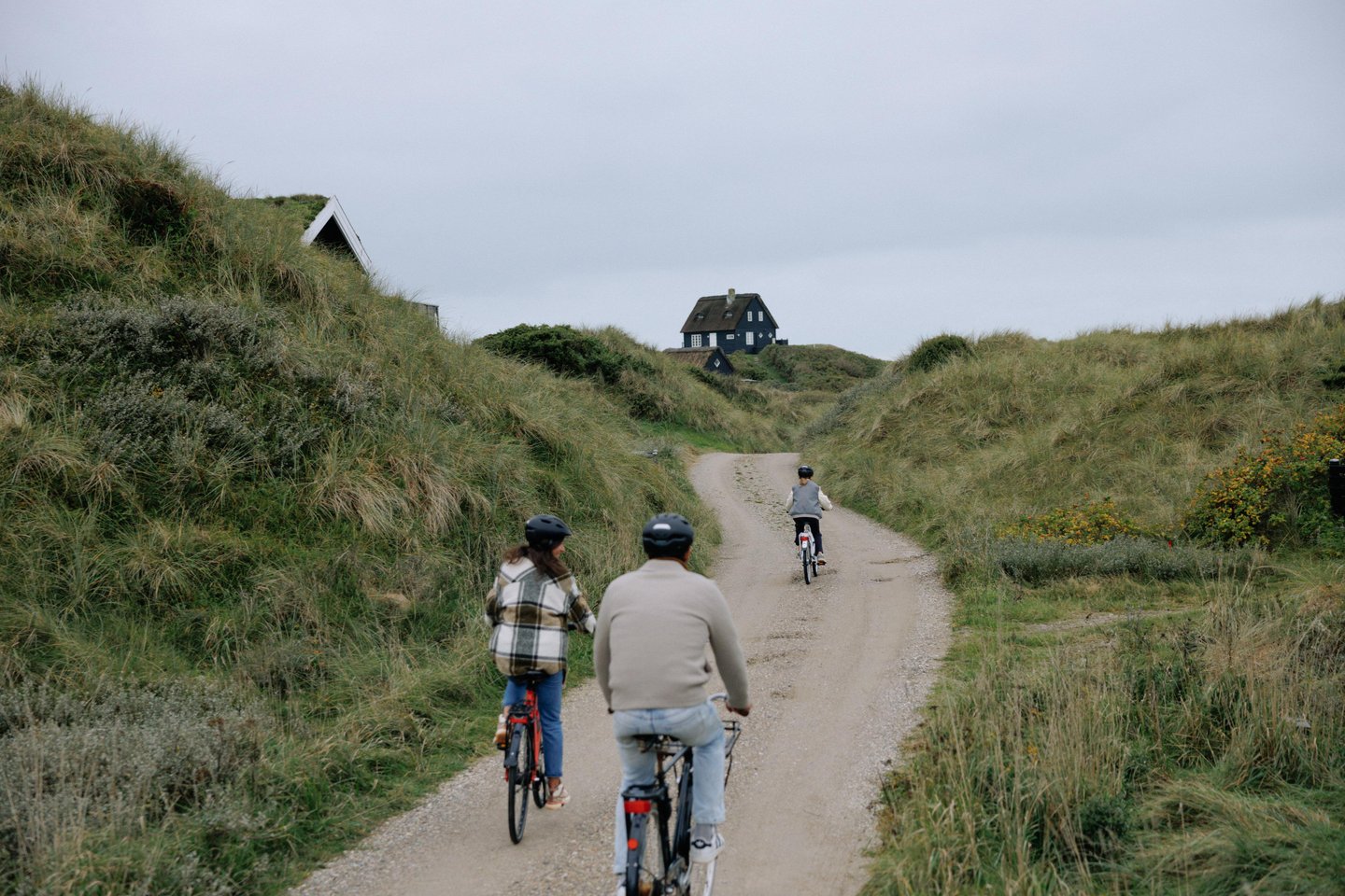 Family cycling to their holiday house at the Danish coast 