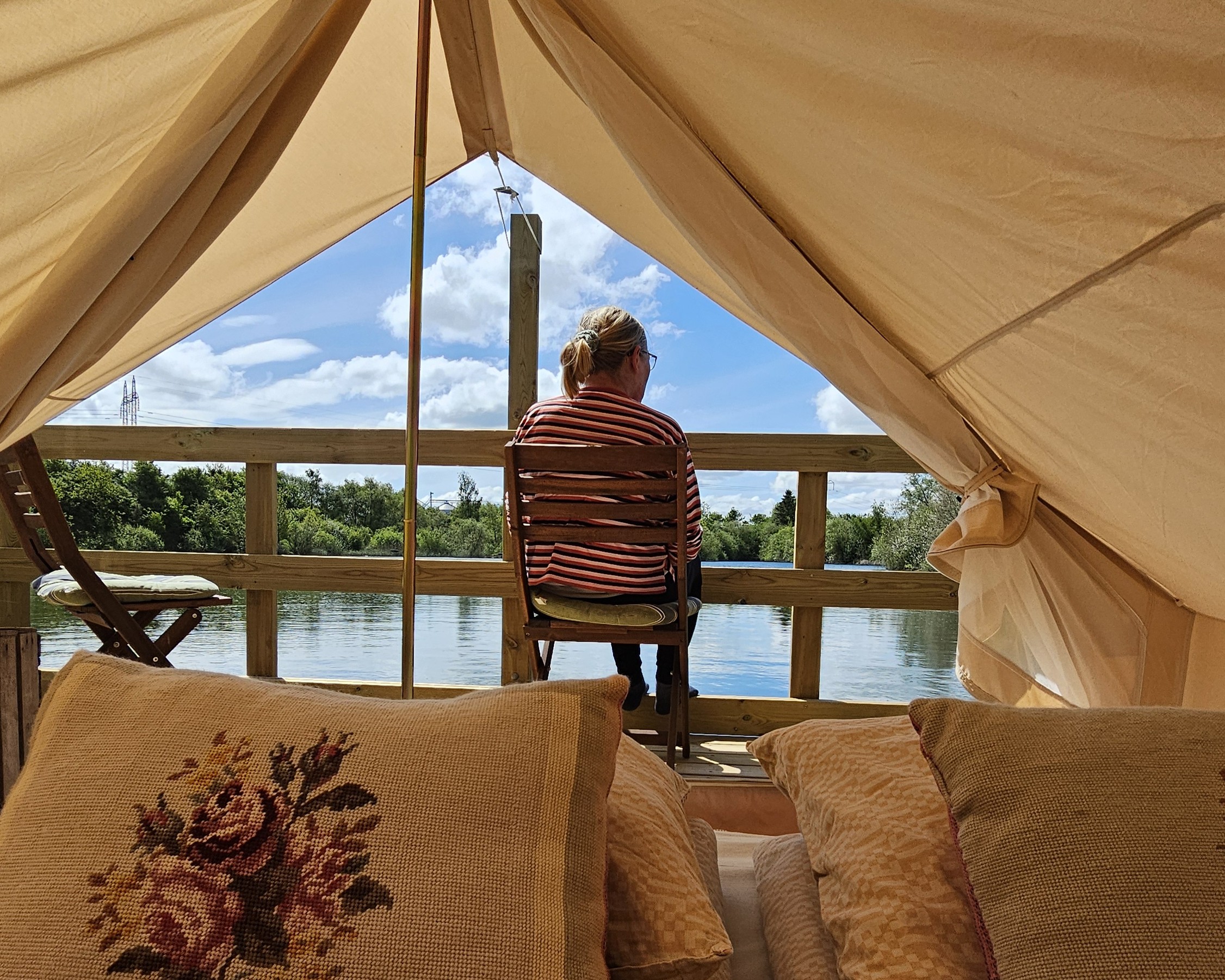 Frau sitzt vor einem Glamping Zelt auf dem Bakkegården