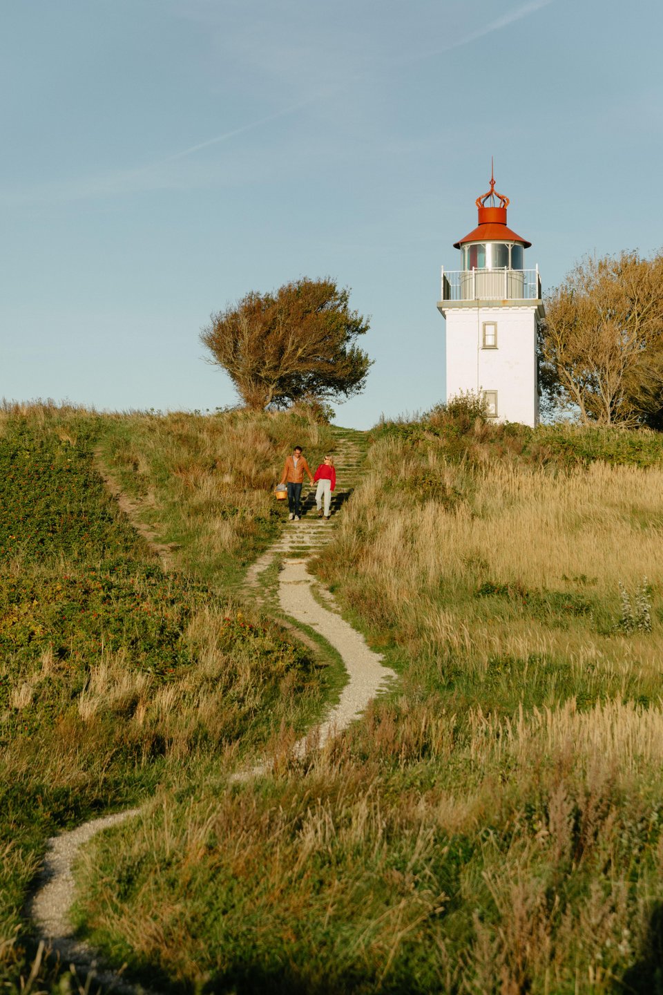 Couple hiking near Spodsbjerg Lighthouse on the Danish coast 
