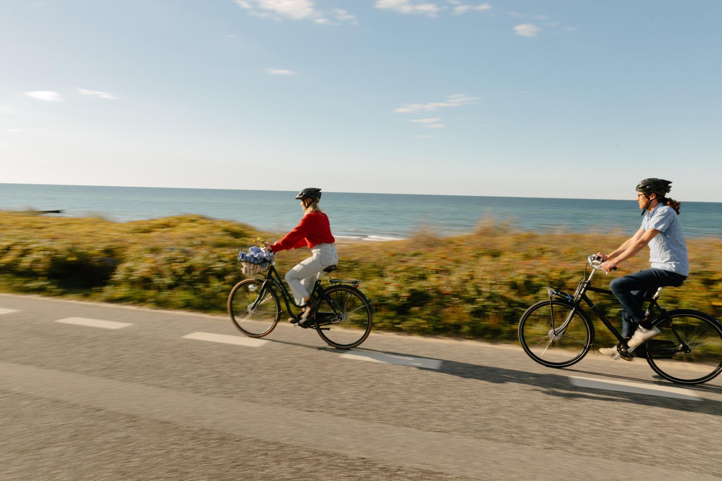 Cyclists cycling along water in North Zealand, Denmark