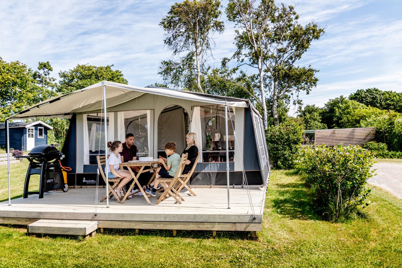 Familie sitzt auf einem Campingplatz in Himmerland