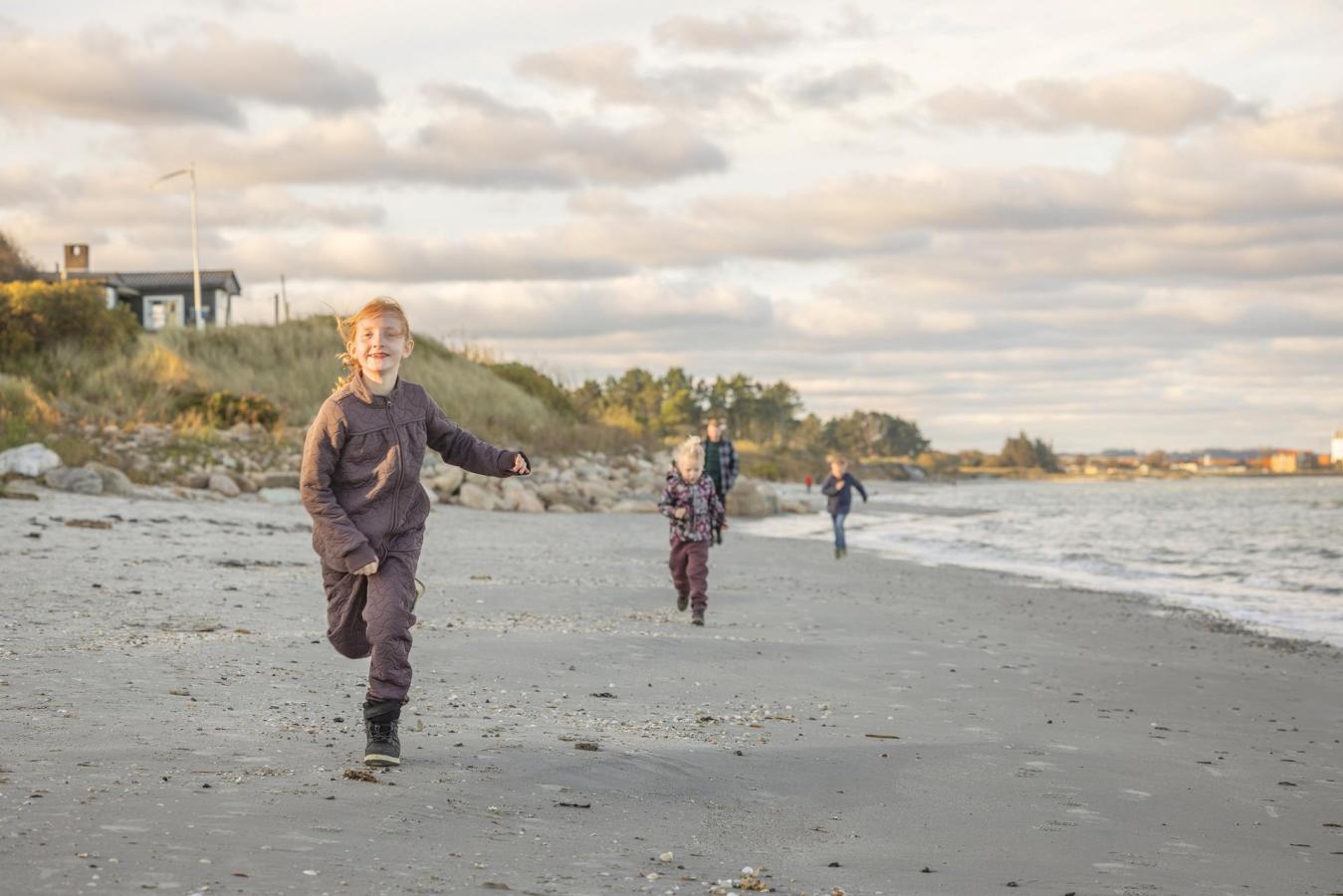 Kinderen rennen op Sæby Strand in het noorden van Jutland aan de Oostzee
