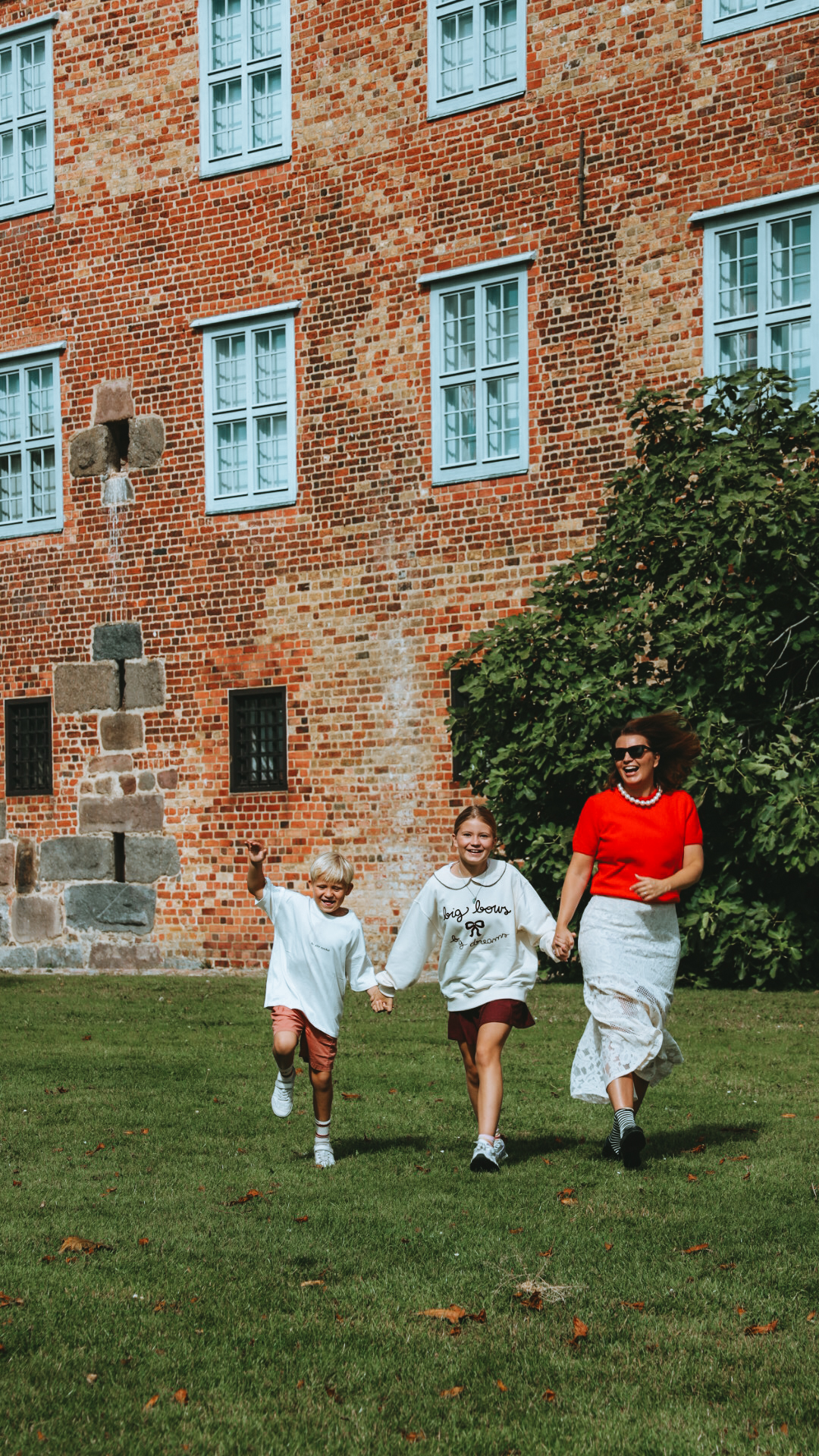 Family running outside a historic building in Sønderborg in South Jutland