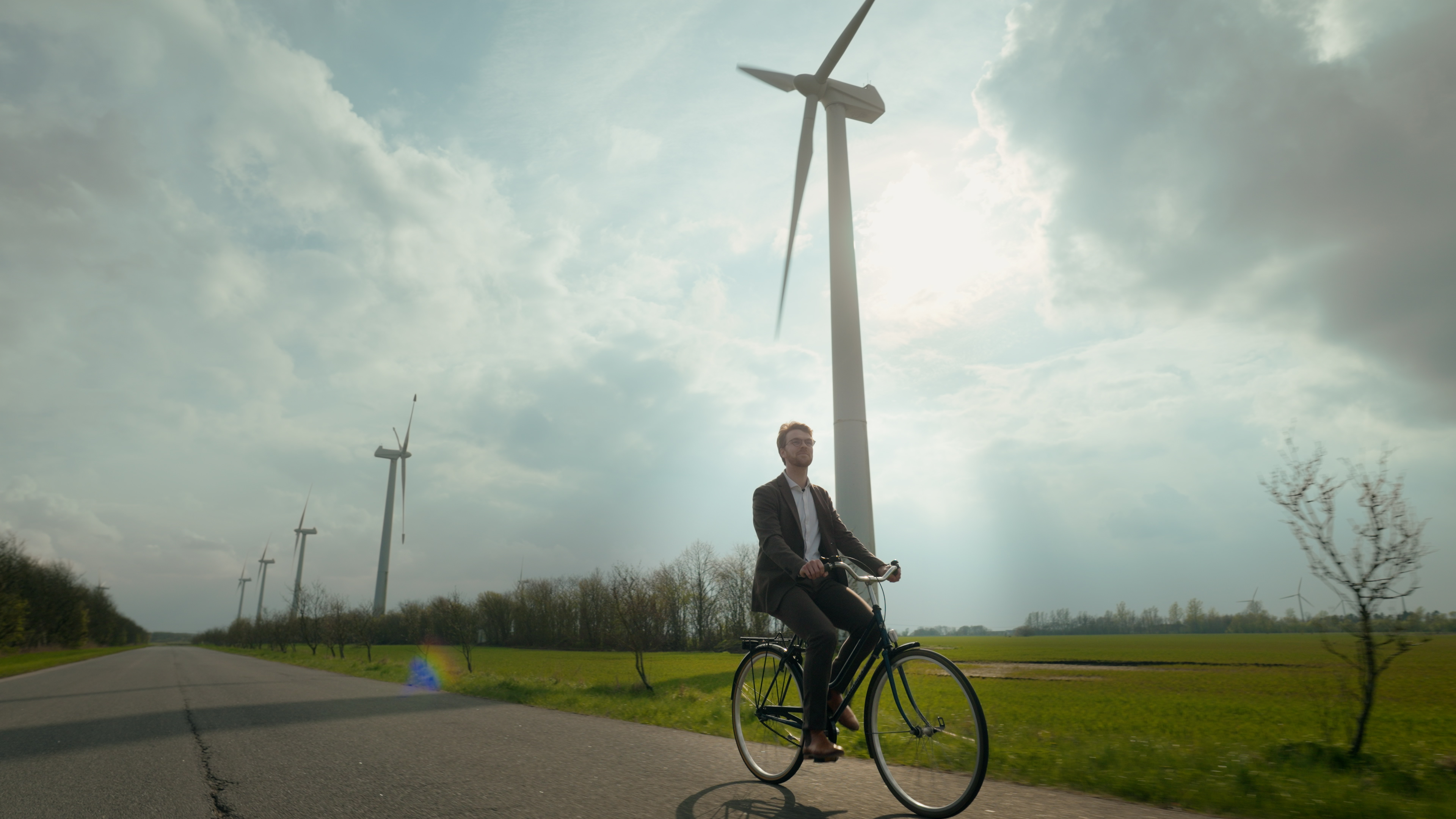 Man cycling infront of windmills