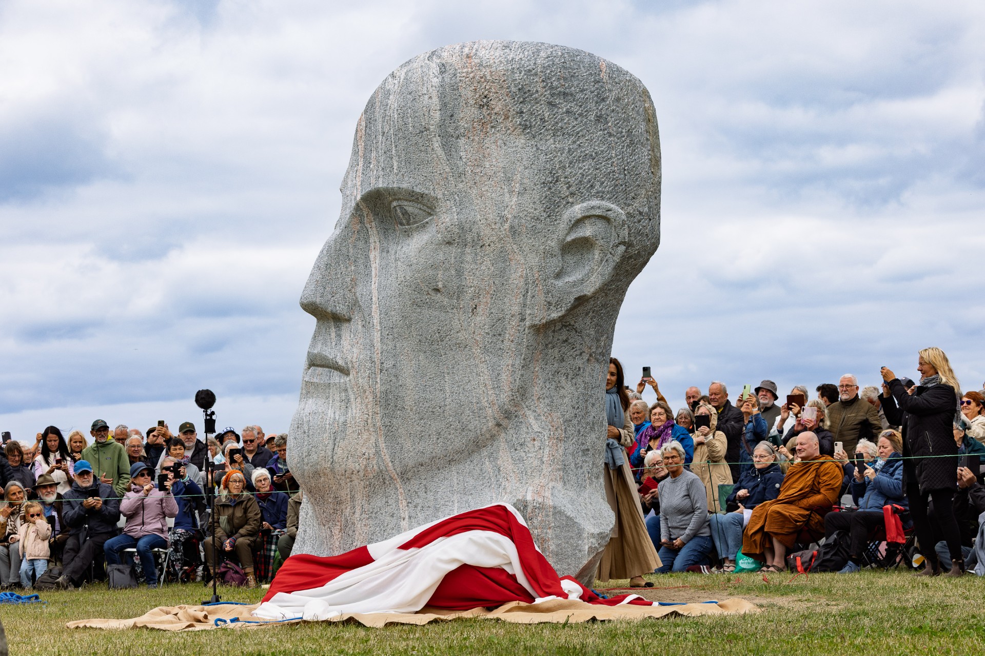 Besucher versammeln sich um eine monumentale Granitskulptur des Kunstprojekts Dodekalitten auf der dänischen Insel Lolland.