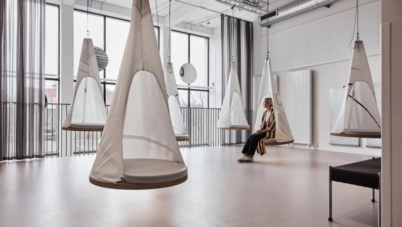 A woman relaxes in a hanging pod at Book1 design hostel in Aarhus, Denmark