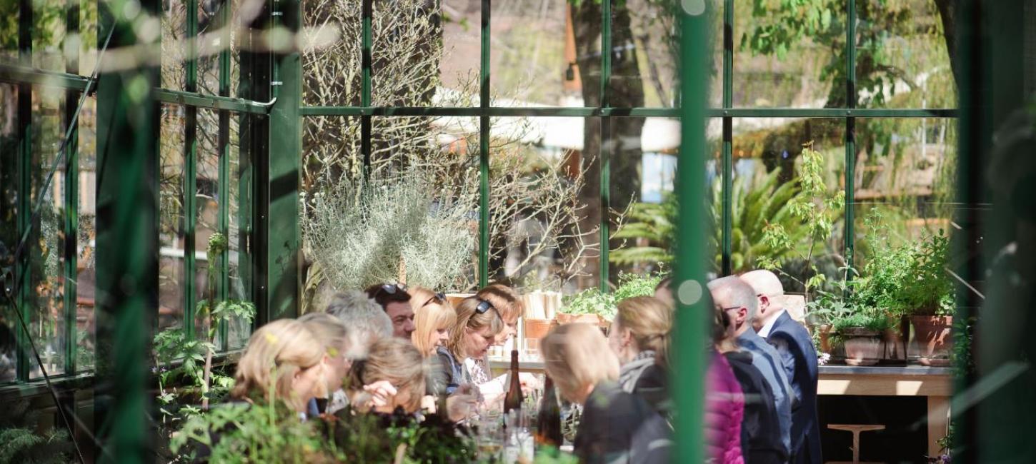 People eating in the greenhouse room at Gemyse Tivoli in Copenhagen