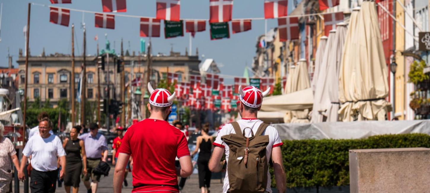 Football fans walk down a Copenhagen street wearing Viking hats and red and white clothes, to celebrate the Euros football championships in Copenhagen, Denmark