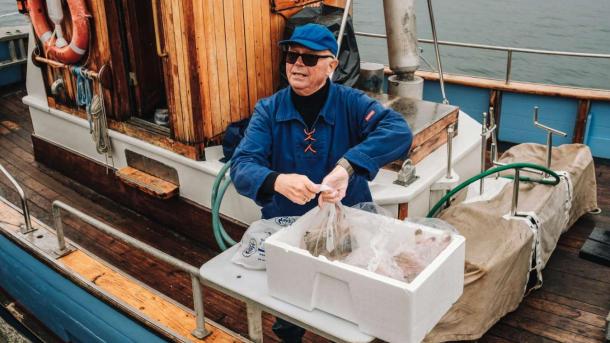 Fischer verkauft frischen Fisch direkt von seinem Fischkutter in Skagen