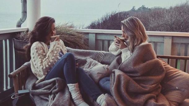 Two women having a cozy time on the terrace at Helenekilde Badehotel in Tisvilde during winter.