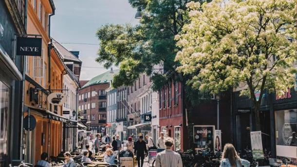 A couple stroll the streets of Odense in summer