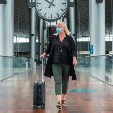 A woman walks through Copenhagen airport in a face mask during the coronavirus period