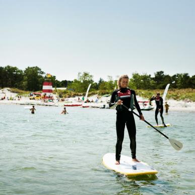 A woman rides a paddleboard - SUP - in Bornholm, Denmark