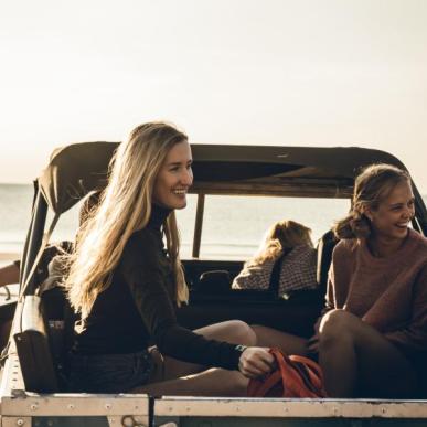 A group of young people travel in the back of a jeep in Lønstrup, Denmark