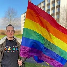 Mona Linaa waving a rainbow flag in Aalborg