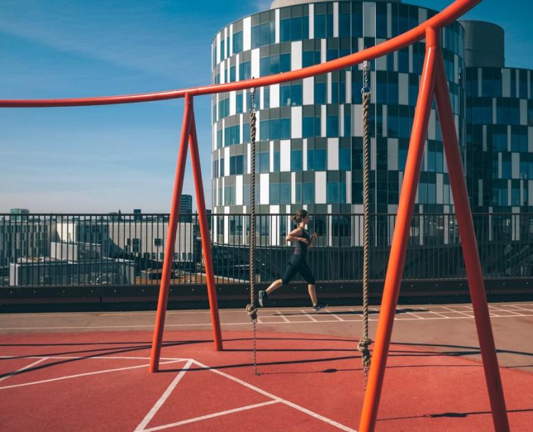 A lady running at the rooftop playground Konditaget Lüders in Nordhavn, Copenhagen, Denmark
