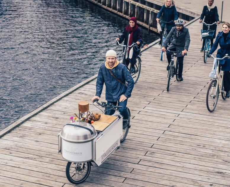 The bike chef biking with group on bridge in Copenhagen