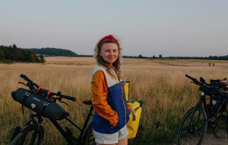 Woman with bikes on cycling trip at Naturparken Hindsgavl Dyrehave near Middelfart, Fyn
